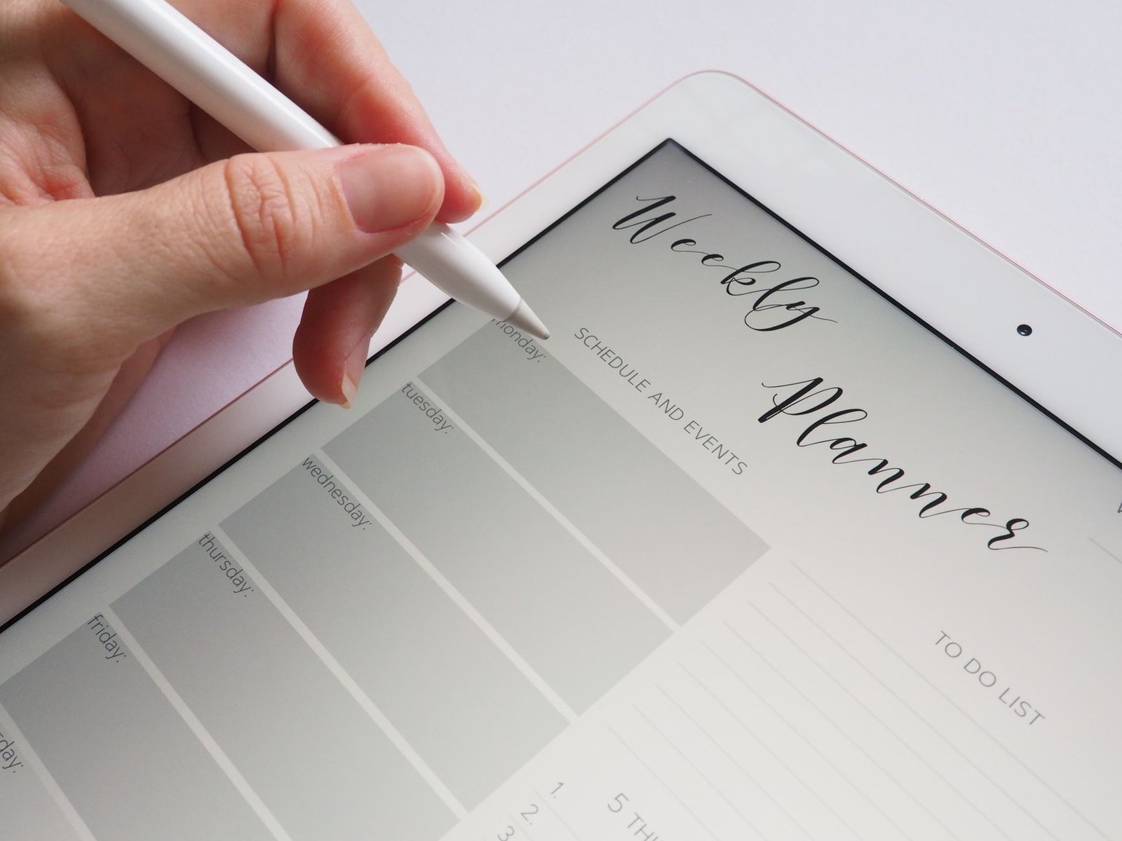 Stylus writing in a digital weekly planner on a tablet