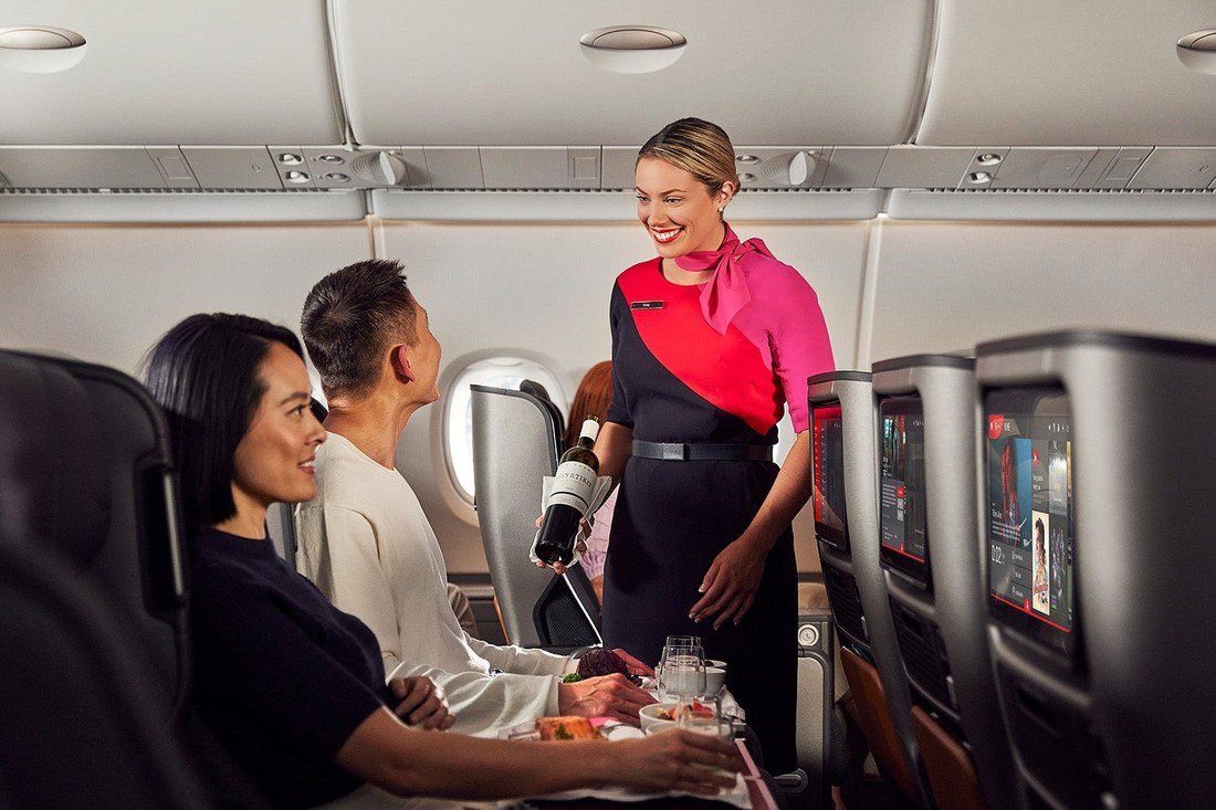 Cabin crew member serving passengers seated in an Airbus A380 cabin