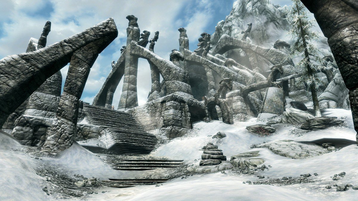 Snow-covered stone ruins with curved Nordic arches and stairs under a blue sky