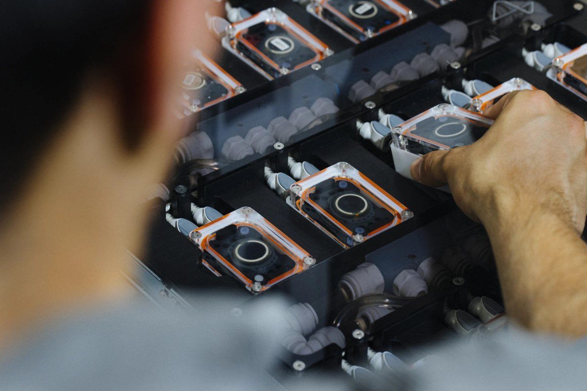 Technician handling implant units in a testing rack