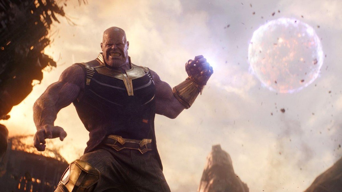 Thanos raises his fist on a rocky battlefield