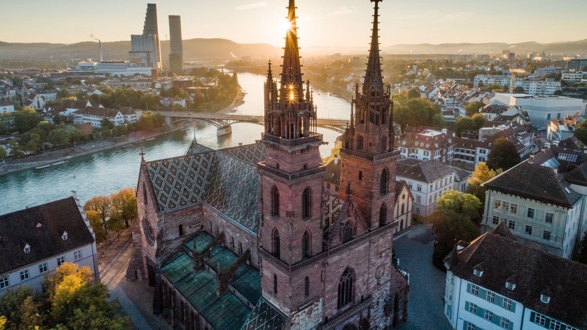 Basel Minster and the Rhine at sunrise with office towers behind