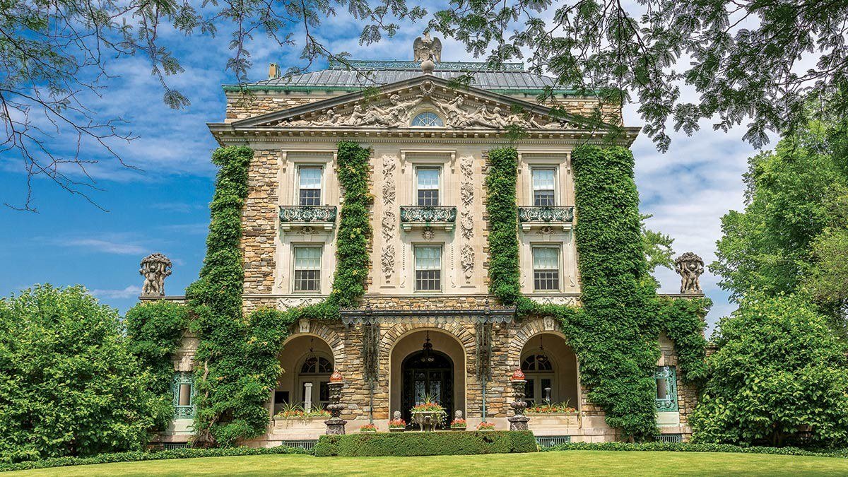 Ivy-covered stone facade of Kykuit, the Rockefeller family estate in Westchester County, under a blue sky