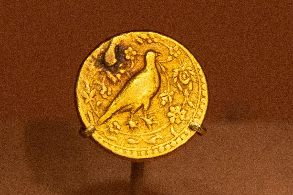 Gold coin with a hawk in relief issued for Akbar and dated 963 AH, 1556 CE